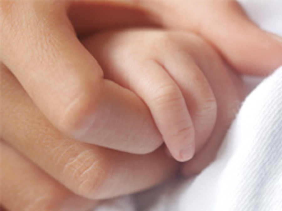 adult and baby holding hands