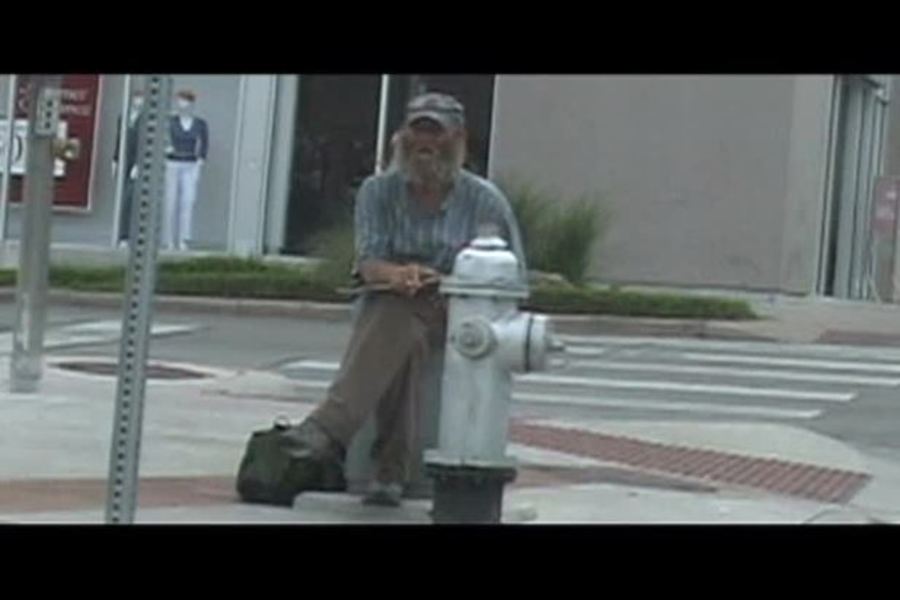 man sitting on the corner of a street