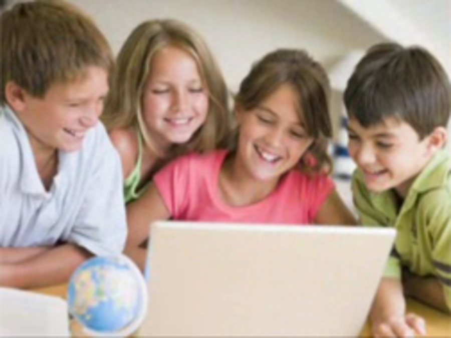 children engaged around a laptop