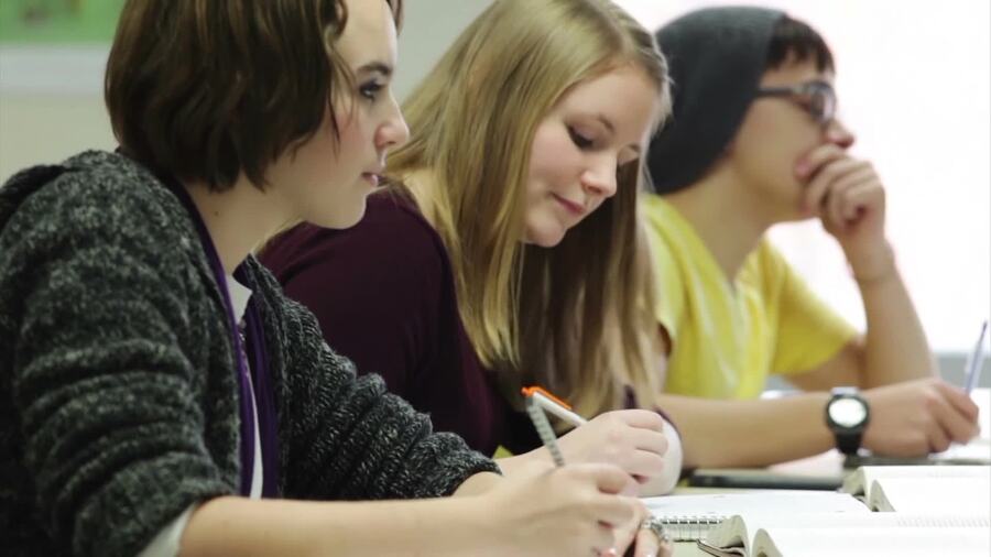three girls taking notes